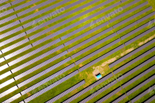 Preview: Aerial view of solar power plant on green field. Electric panels for producing clean ecologic energy