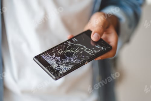 Preview: Hand holding broken mobile phone with cracked screen, selective focus. Technology, service