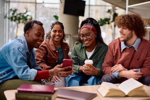 Preview: Multiracial group of happy student watching something on cell phone at the university.