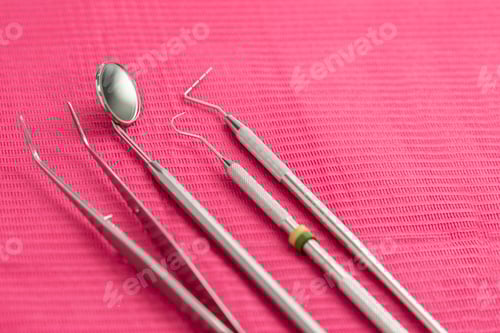 Preview: close up of dentist tools on fuchsia background
