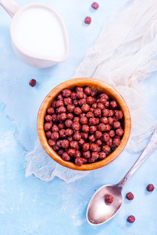 Bowl of Chocolate Cereal with Milk and Spoon