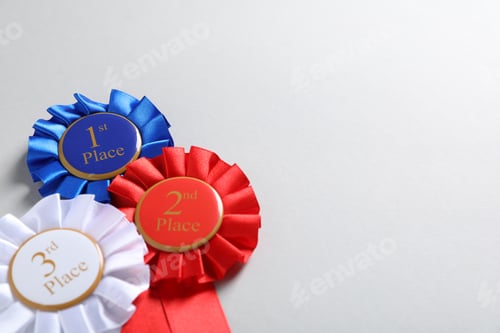 Preview: Colorful award ribbons on light grey background, above view. Space for text