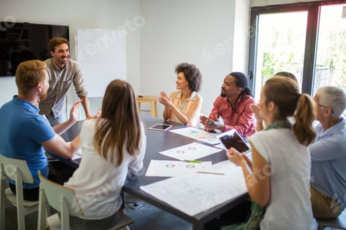 Preview: Group of business partners discussing documents and ideas at meeting in corporate office