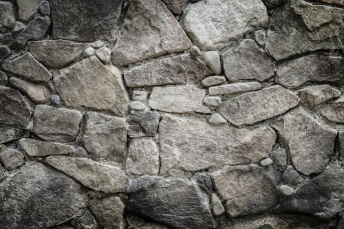 Preview: Black stones and rocks of different shape, gray background