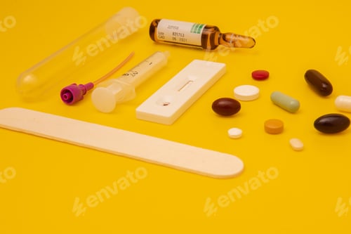 Preview: Top view of syringe, pills, and a thermometer on yellow background