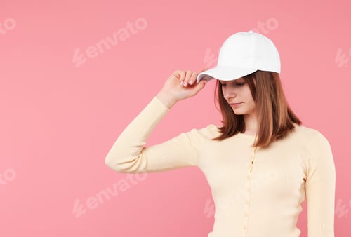 Preview: Young woman wearing stylish white baseball hat on pink background, space for text