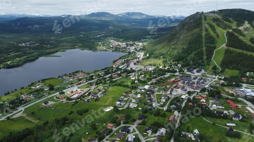 Preview: Aerial view of a picturesque town, a lake and forested mountains