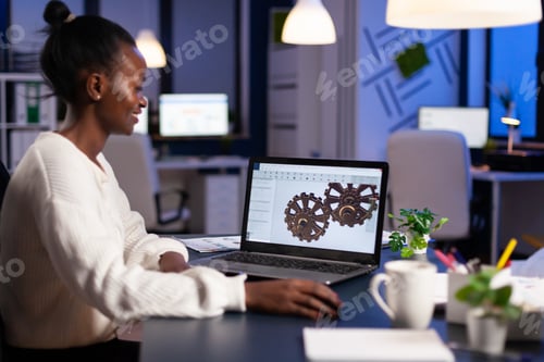 Preview: African engineer working late at night on a 3D model of industrial gears