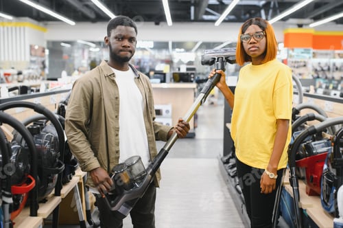 Preview: African american Couple choosing vacuum cleaner, electronics store.