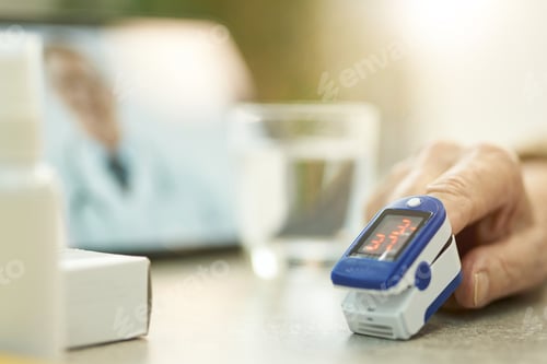 Preview: Man using fingertip oximeter and video-calling medical doctor