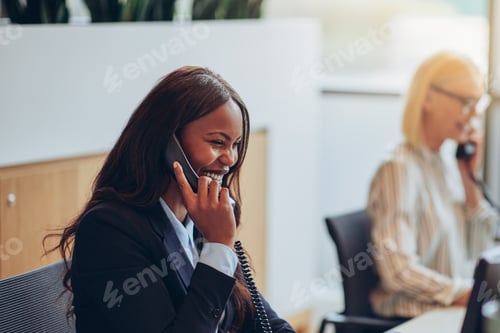 Preview: Laughing businesswoman talking on the telephone at an office reception