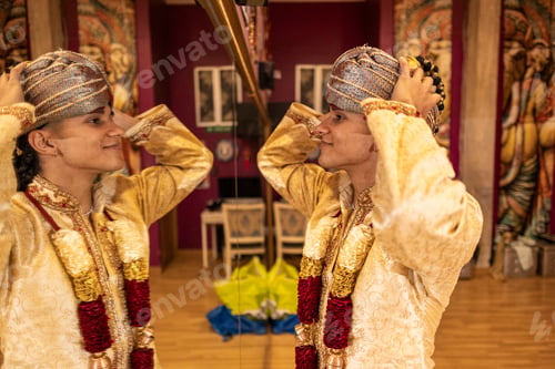 Preview: young indian man placing his traditional indian clothes, in front of the mirror, in the dance hall