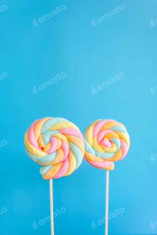 Preview: Rainbow twist roll marshmallow like lollipop on blue background
