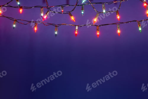 Preview: Christmas lights string on blue background with copy space