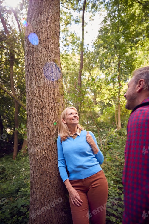 Preview: Mature Couple In Countryside Hiking Along Path Through Forest Together