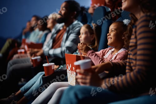 Preview: Happy black girl enjoying in movie projection at the cinema.