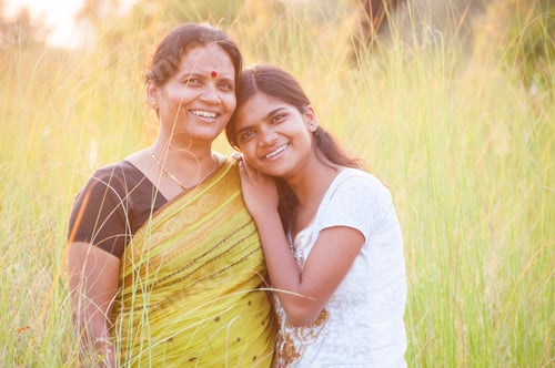 Preview: Portrait of happy mother and daughter in meadow at sunset. Smart Blurred photo