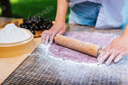 Preview: a person is rolling dough with a rolling pin on a table. Mochi asian dessert