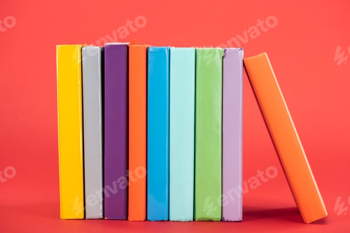 Preview: Colorful books with bright hardcovers on red surface
