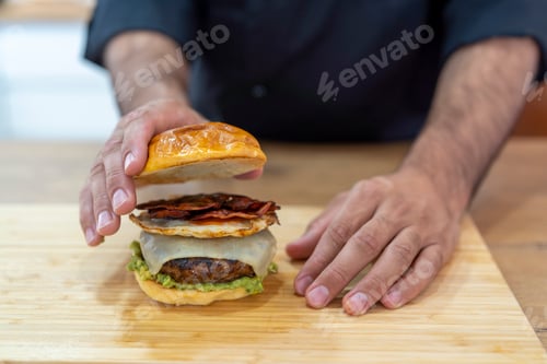 Preview: Chef seasoning a delicious hamburger
