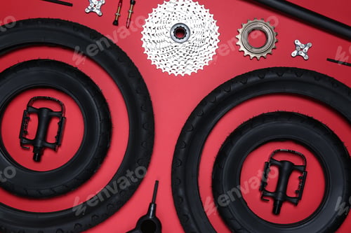 Preview: Set of different bicycle tools and parts on red background, flat lay