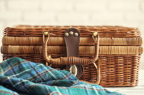 Preview: Close up of a wooden basket with dishware on white table