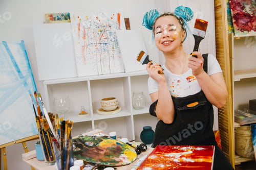Preview: Artist girl painting of pictures in her art studio and smiling