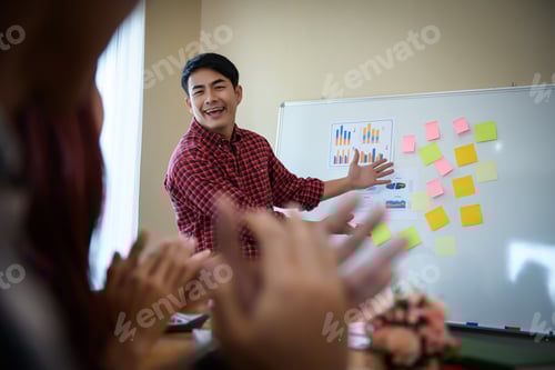 Preview: Young man standing near presentation perfect planning business with people group clapping.