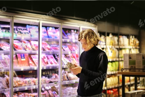 Preview: Young Man Shopping In Supermarket, Reading Product Information