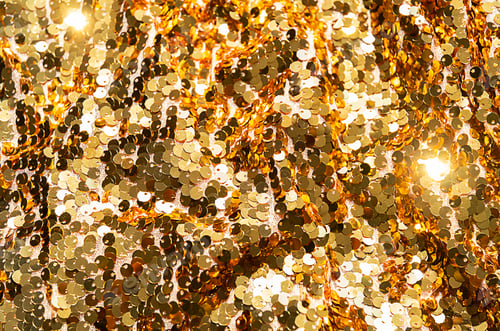 Preview: Close up of golden sequins fabric texture with shining light.