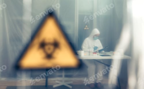 Preview: Scientist investigating in the laboratory behind a protective curtain