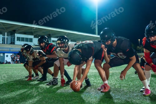 Preview: American football players lining up for kickoff at night game