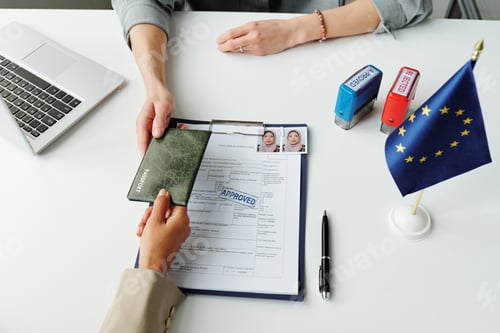 Preview: Giving Passport To Consular Officer At Table