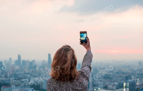 Preview: Woman taking a photo of the sunset