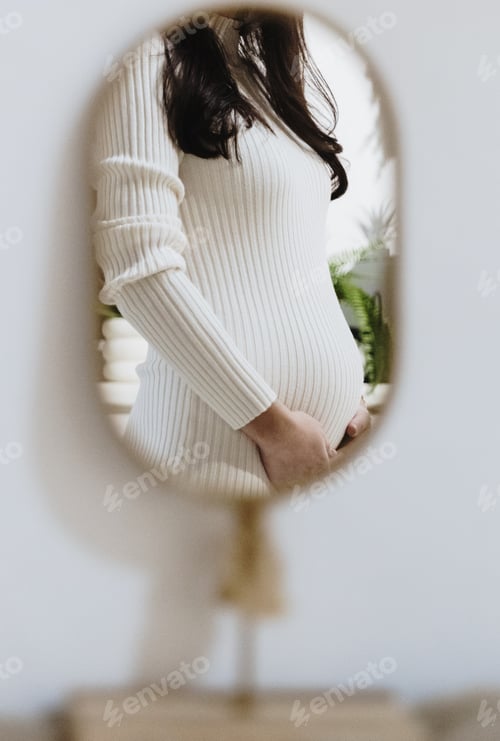 Preview: Reflection of a pregnant woman in a mirror.