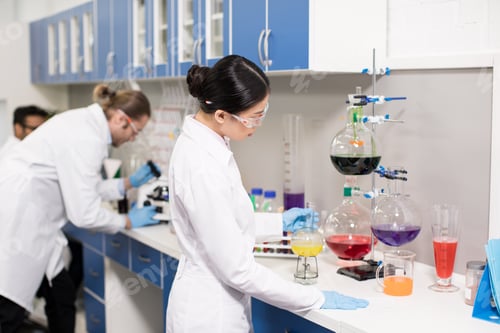 Preview: Group of young professional scientists making experiment in research laboratory