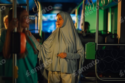 Preview: Muslim woman wearing hijab riding public transport bus