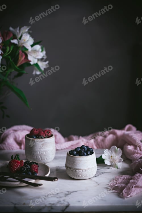 Preview: Raspberries and blueberries on glasses on table
