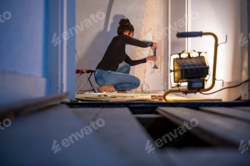 Preview: A focused individual engaged in a DIY home renovation project.