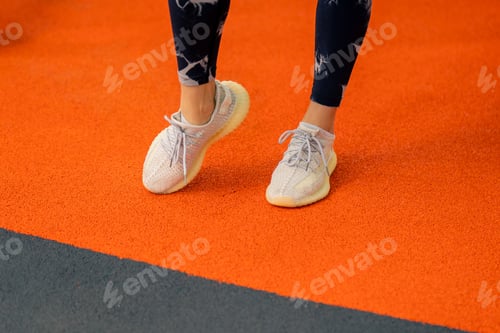 Preview: close-up of a girl in sportswear in the gym doing leg exercises before starting a workout