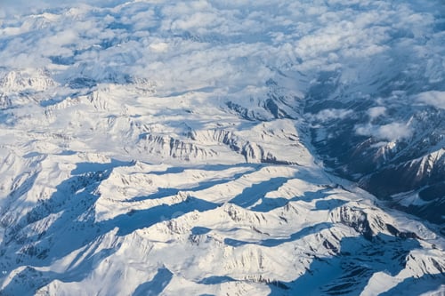 Preview: Aerial view of snow-covered mountains with clouds.