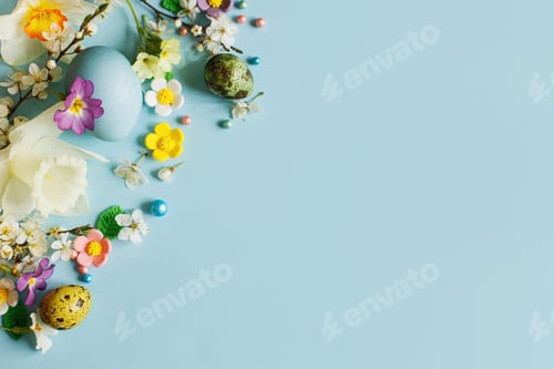 Preview: Stylish easter eggs, candy and blooming flowers on blue background flat lay. Happy Easter!