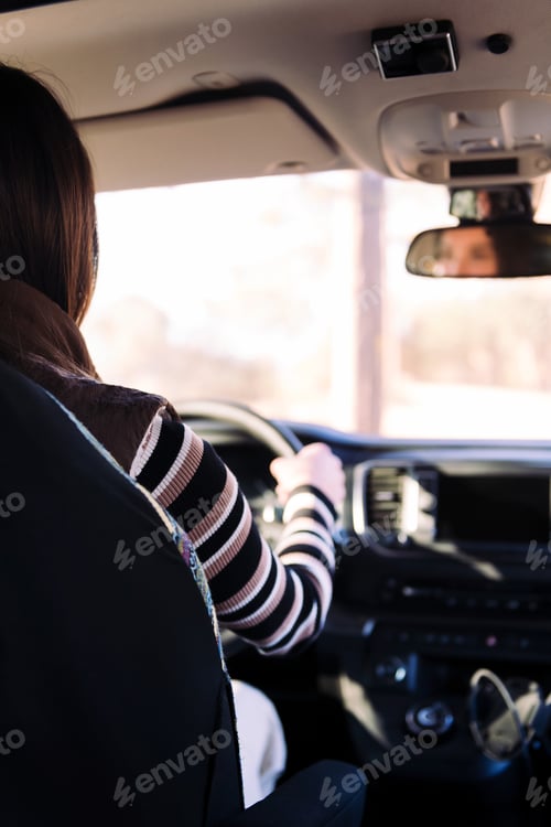 Preview: rear view of a young woman driving her camper van