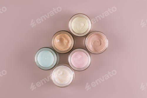Preview: A set of glass jars with cosmetic cream of different colors for face and body skin care. mockup.
