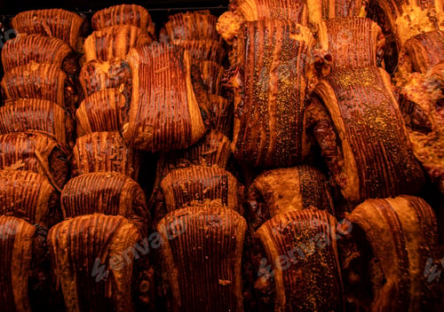 Preview: Closeup shot of a variety of freshly baked goods in a tray illuminated by warm light