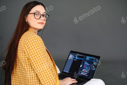 Preview: Portrait of young woman mobile developer with laptop, writes program code on a computer