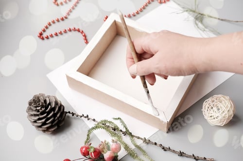 Preview: female hand painting gift box in white