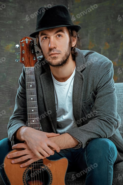 Preview: Cool guy sitting with guitar on gray background