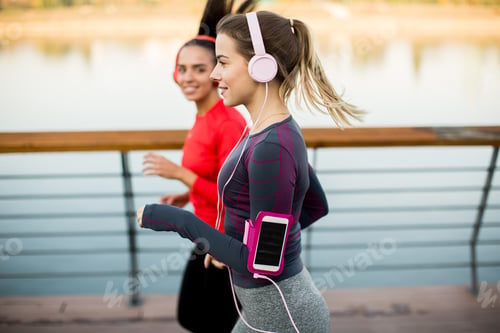 Preview: Young women running by the river in the morning