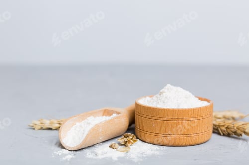 Preview: Flat lay of Wheat flour in wooden bowl with wheat spikelets on colored background.